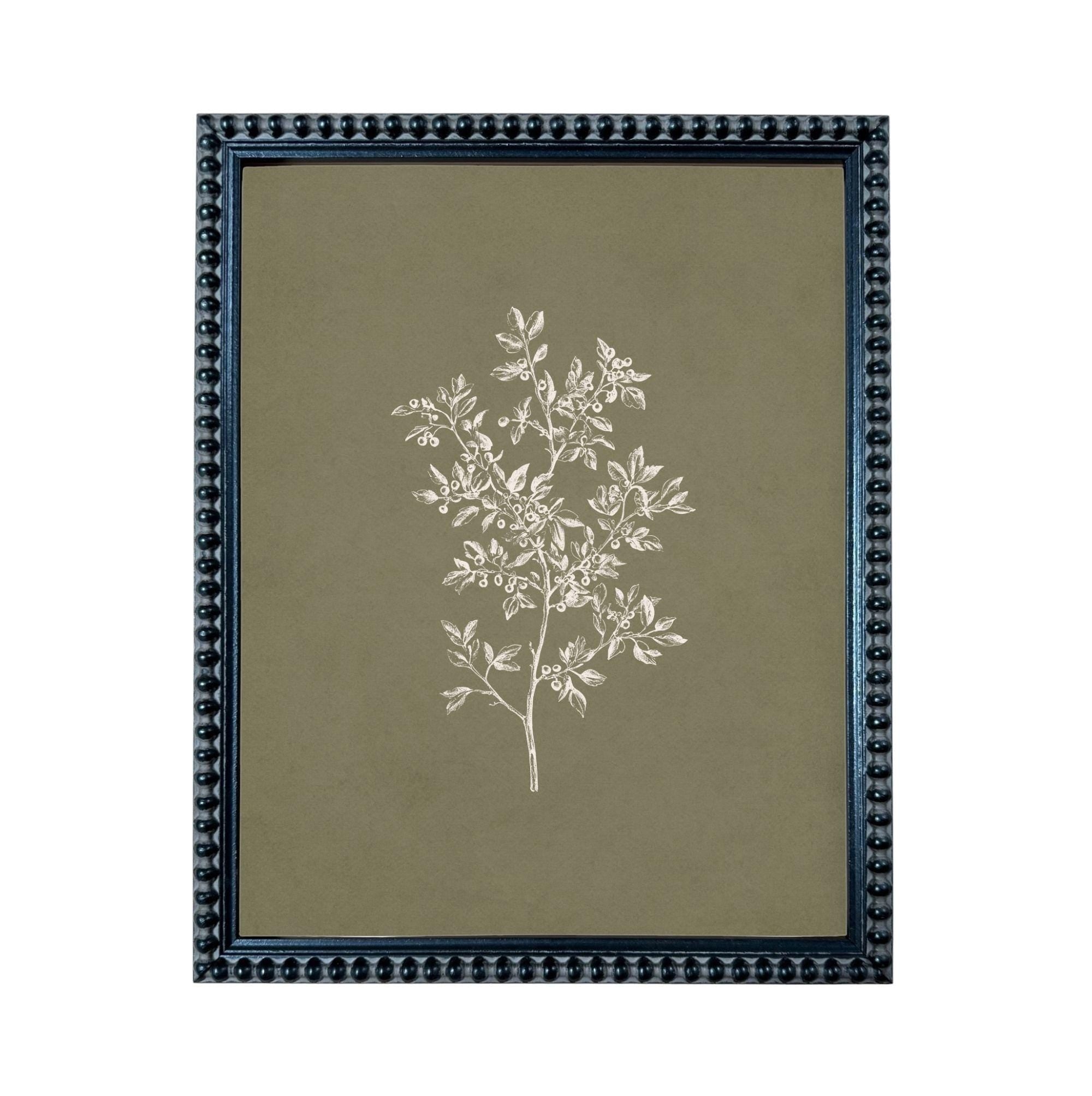 A framed print of a white tree with green leaves, displayed in a dark blue frame with a textured border.