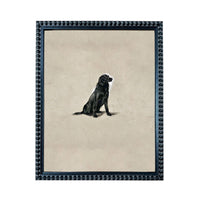 A black dog sitting on a beige background, framed in a black frame with a decorative border.
