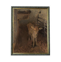 a young calf standing in a pen, with a wooden fence and a hay feeder visible in the background.