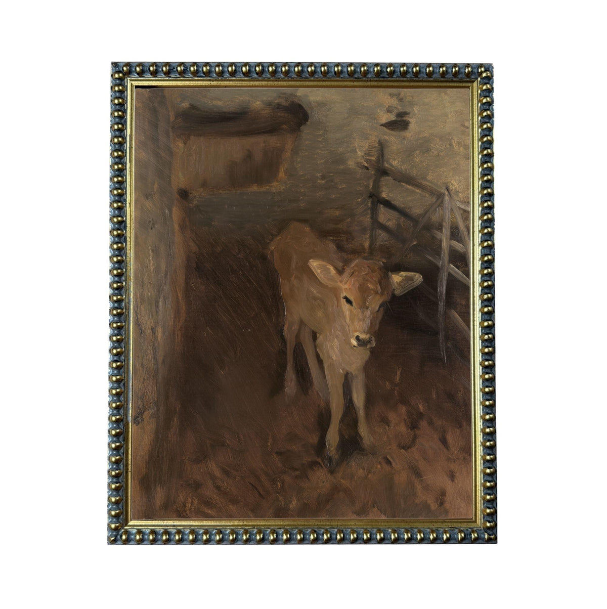 a young calf standing in a pen, with a wooden fence and a hay feeder visible in the background.