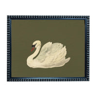 A framed image of a white swan with a red beak, set against a dark green background.