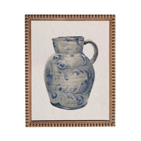 A blue and white ceramic pitcher with a floral pattern on its surface, displayed in a framed artwork.