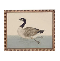 A painting of a duck swimming in a body of water, framed in an ornate brown frame.