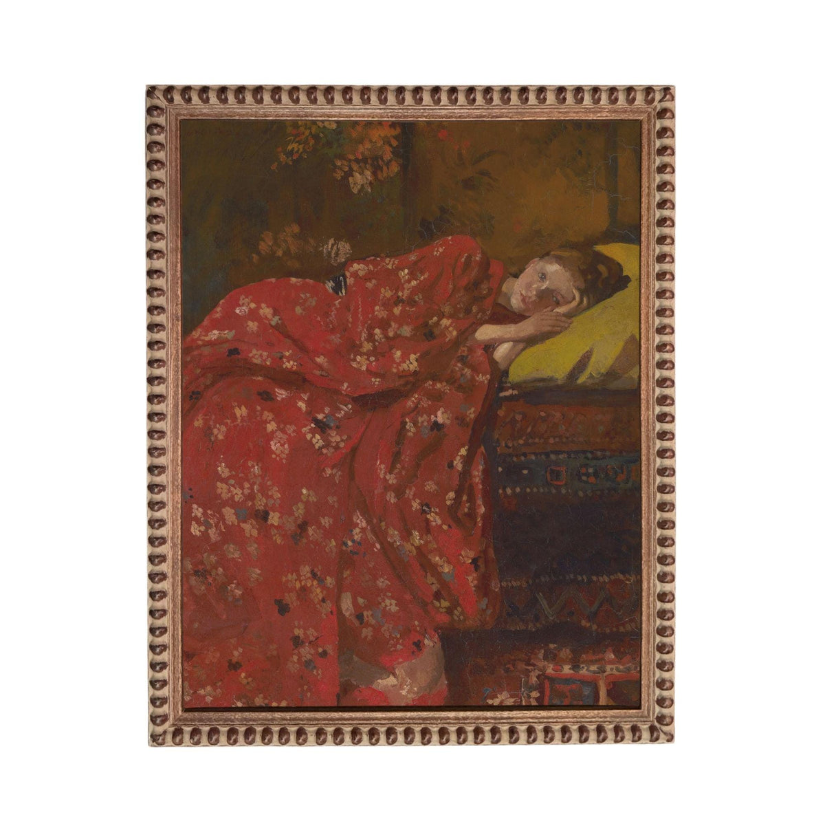 a woman wearing a red dress with a floral pattern, lying down and resting her head on her hand.