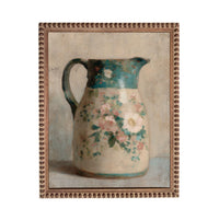 A framed painting depicting a floral-patterned pitcher.