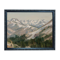 The image is a framed painting depicting a mountainous landscape with snow-capped peaks, lush forests, and a winding path through the terrain.